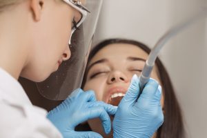 Dentist doing a dental treatment on a female patient.
